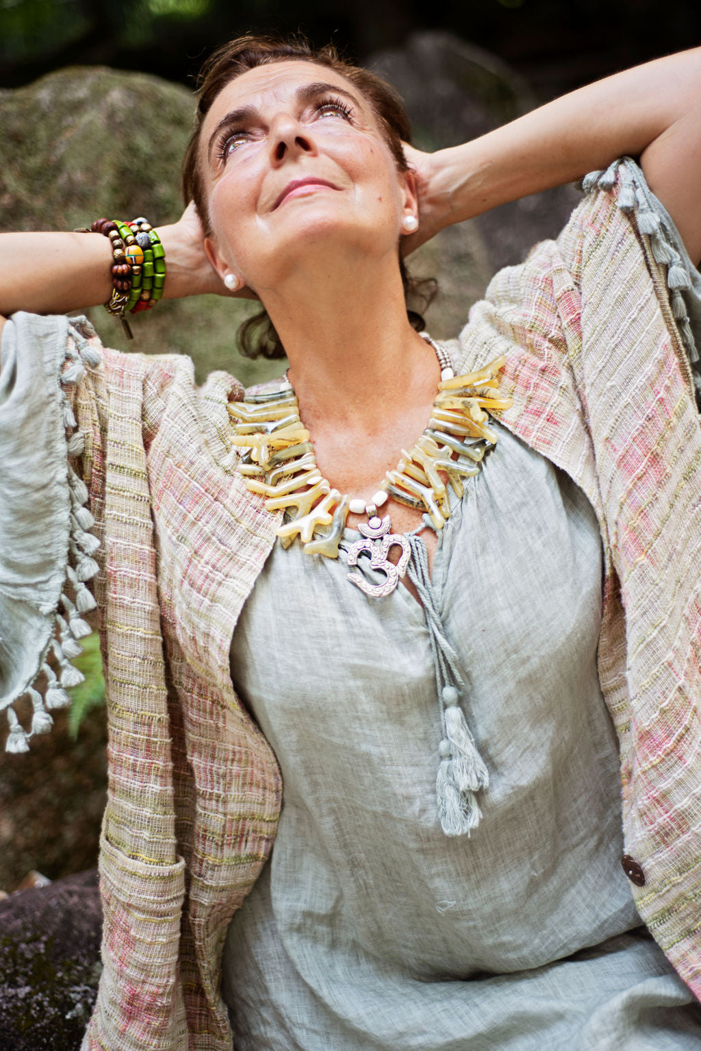 Model wearing a beautiful soft green necklace with coral shapes in resin with Om centerpiece. Cristina Tamames Jewelry Designer