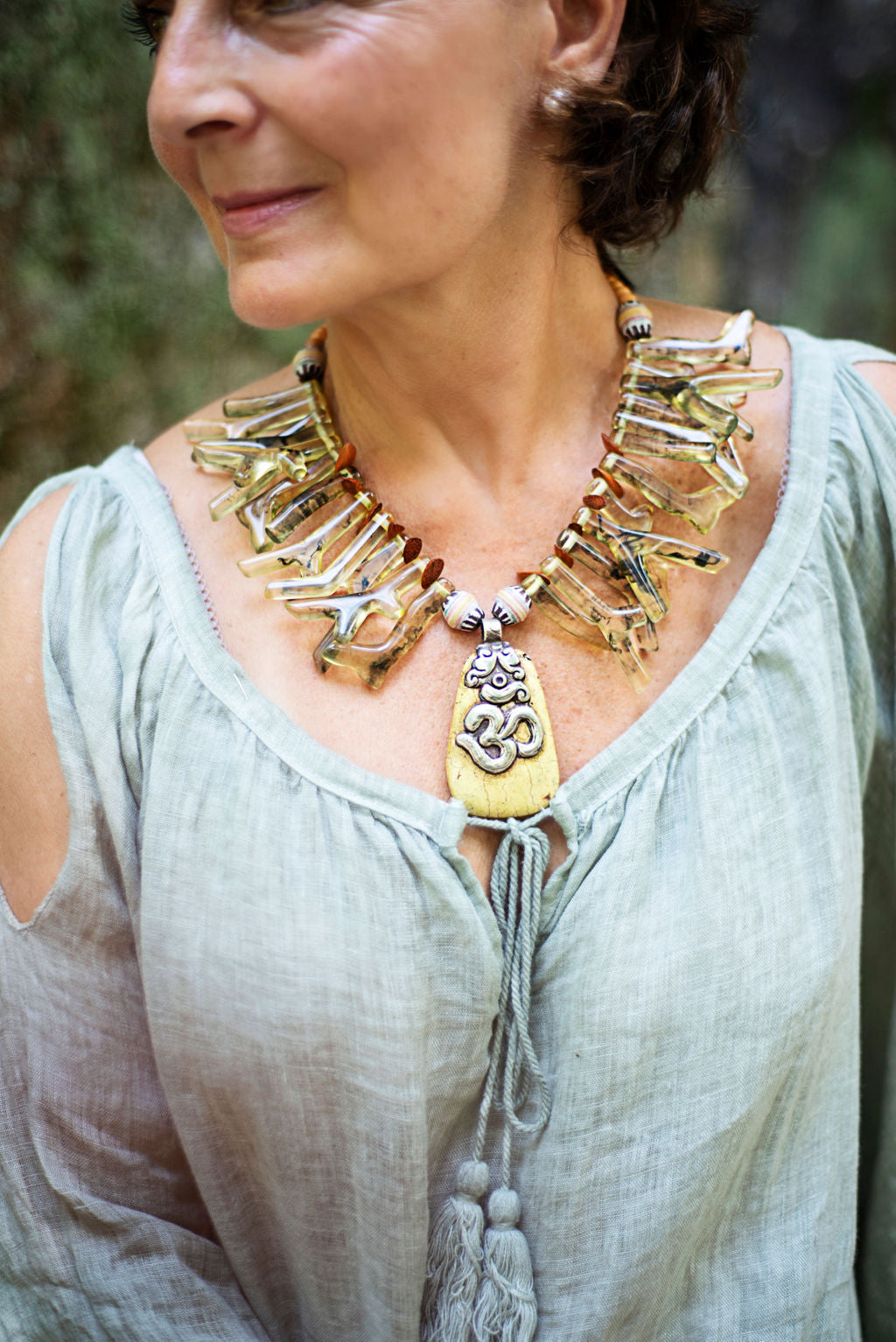 Model wearing a beautiful yellow turquoise with Om from Nepal complimented by green-yellow coral resins makes this one of a kind necklace a good companion to wear any day of the year. Cristina Tamames Jewelry Designer