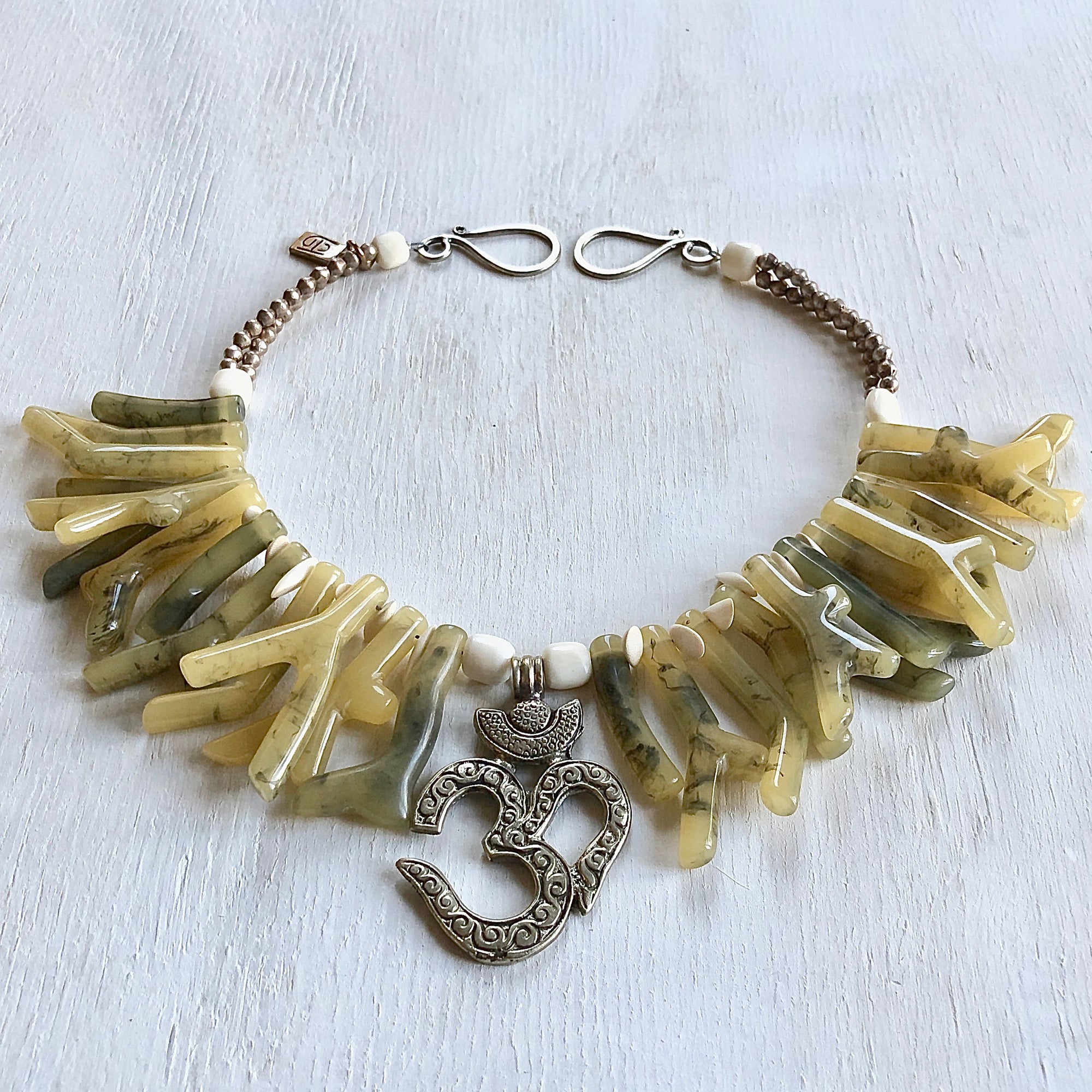 A beautiful soft green necklace with coral shapes in resin with Om centerpiece. Cristina Tamames Jewelry Designer