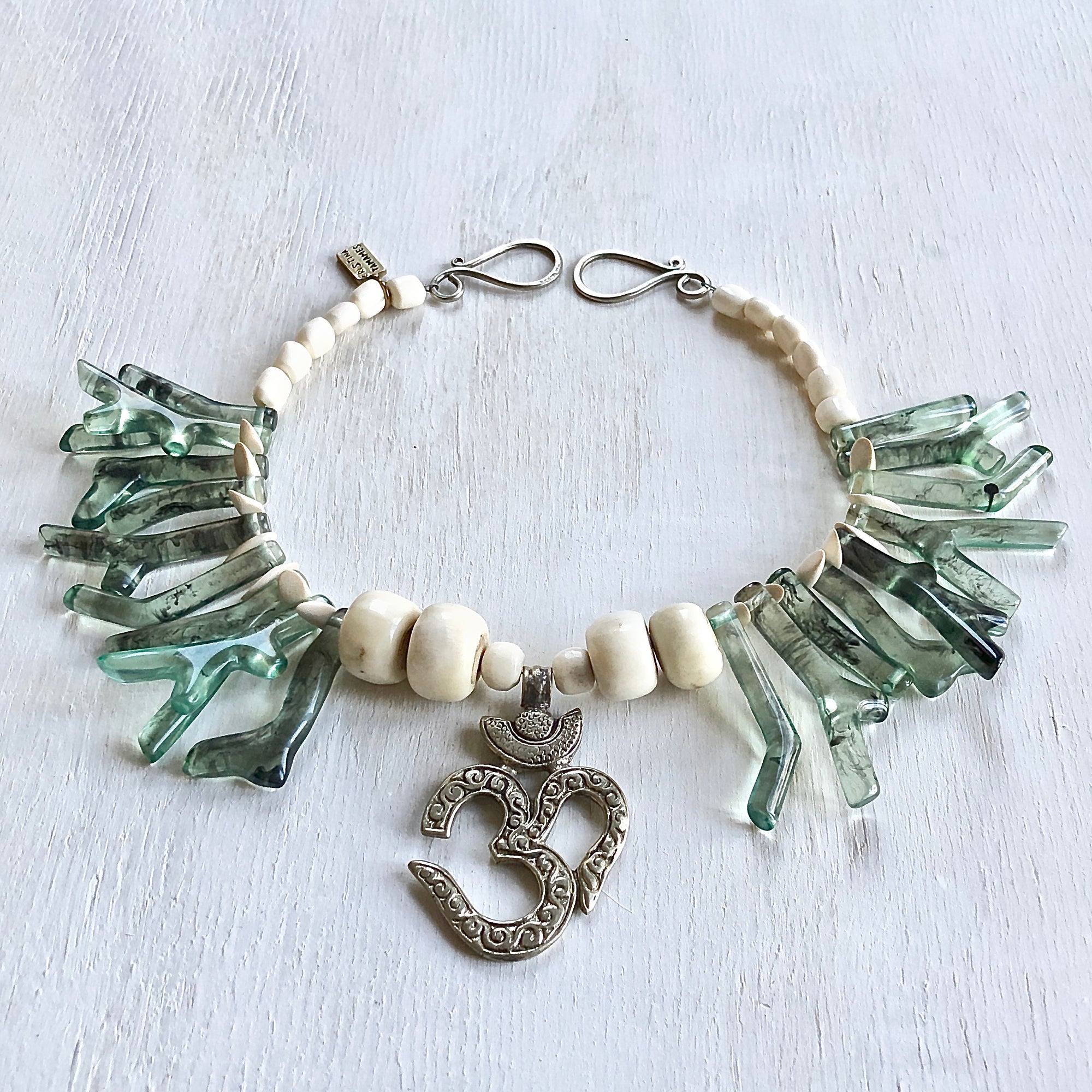 Green coral shapes in resin with an Om center piece one of a kind necklace. Cristina Tamames Jewelry Designer