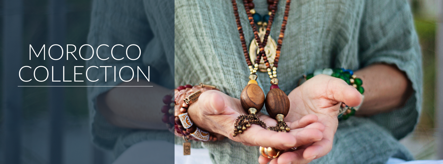 Morocco Collection Banner Image Woman in blue shirt holding beaded necklaces and bracelets
