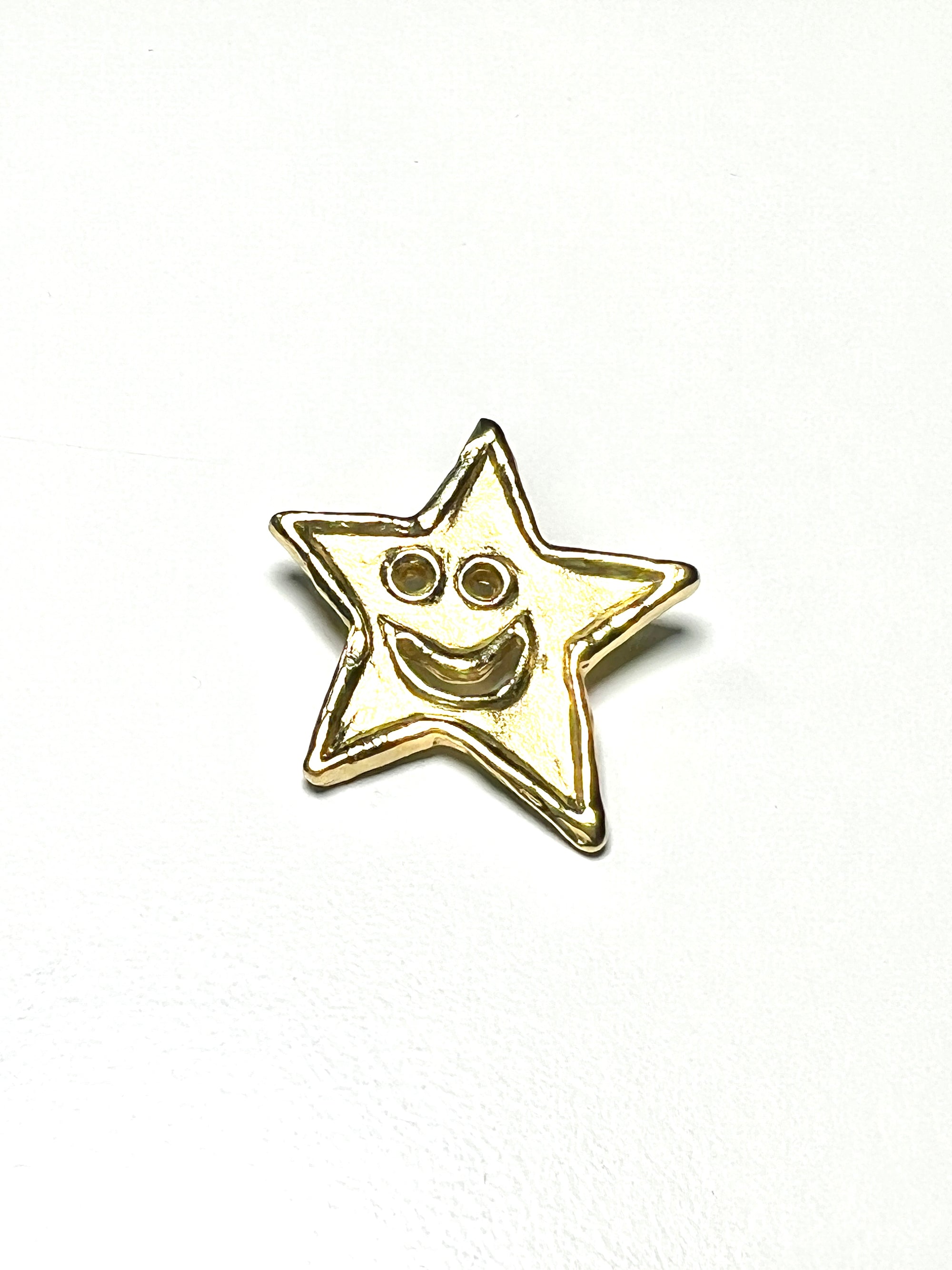 18kt Gold star-shaped pendant with a smiley face on a white background