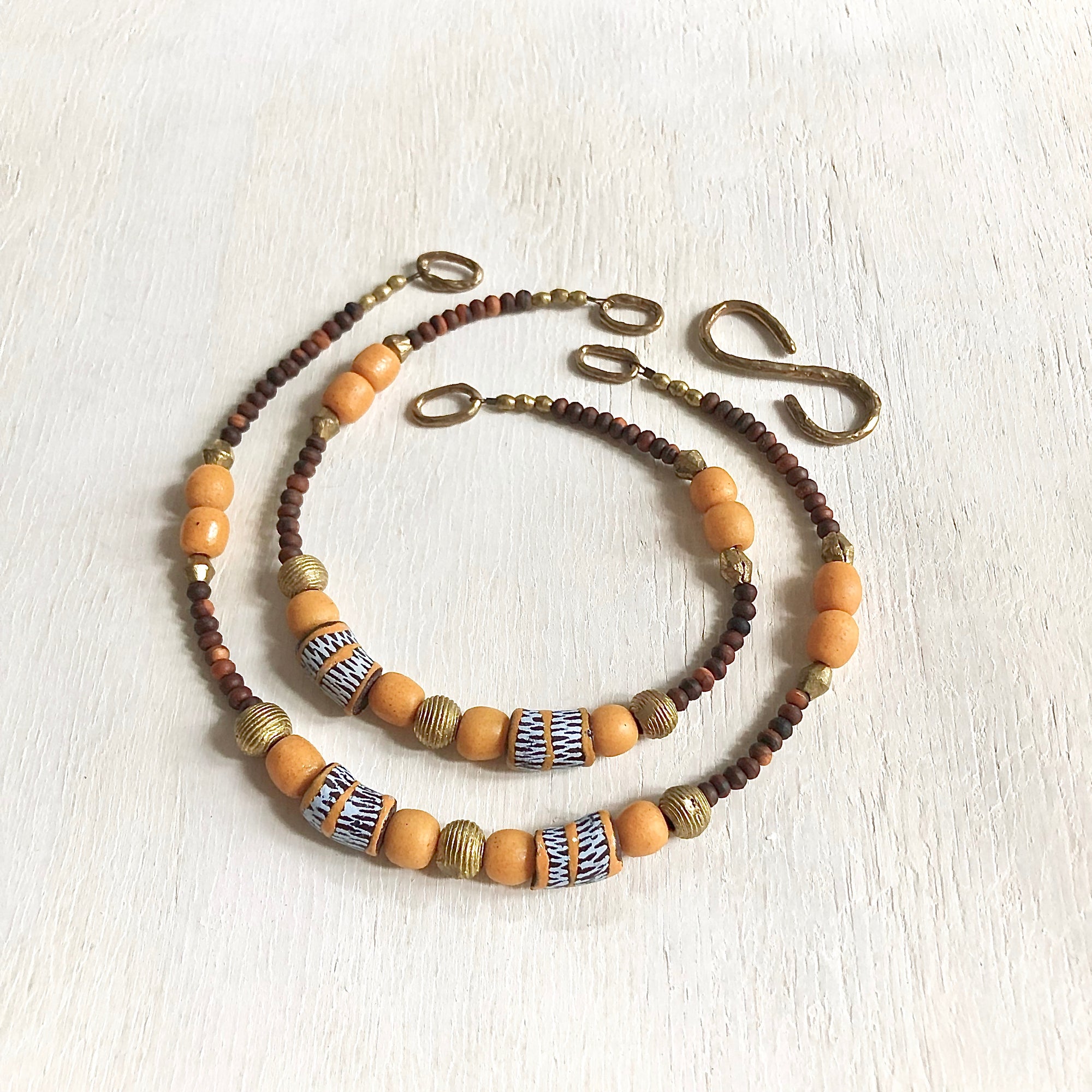 Hand painted brown yellow Adinkra African beads with vintage olive wood pendant long necklace. Cristina Tamames Jewelry Designer