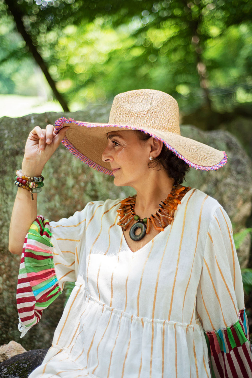 Model wearing a light and easy to wear one of a kind necklace in a beautiful orange tone accented by an ebony big center circle. Cristina Tamames Jewelry Designer