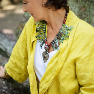 Model wearing a one of a kind necklace made out of  a variety of greens, in the shapes of beautiful corals from the ocean. Light and easy to wear. Cristina Tamames Jewelry Designer 