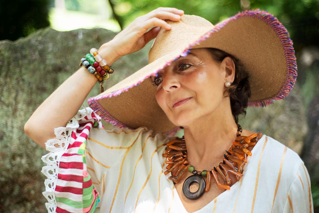 Model wearing a light and easy to wear one of a kind necklace in a beautiful orange tone accented by an ebony big center circle. Cristina Tamames Jewelry Designer