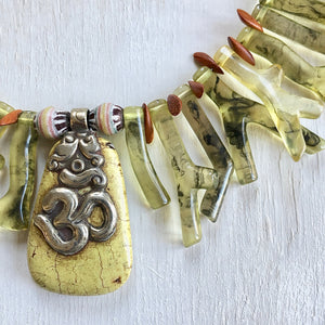 Coral green shapes made out of resin with an Om yellow turquoise pendant as the center piece of this one of a kind necklace. Cristina Tamames Jewelry Designer