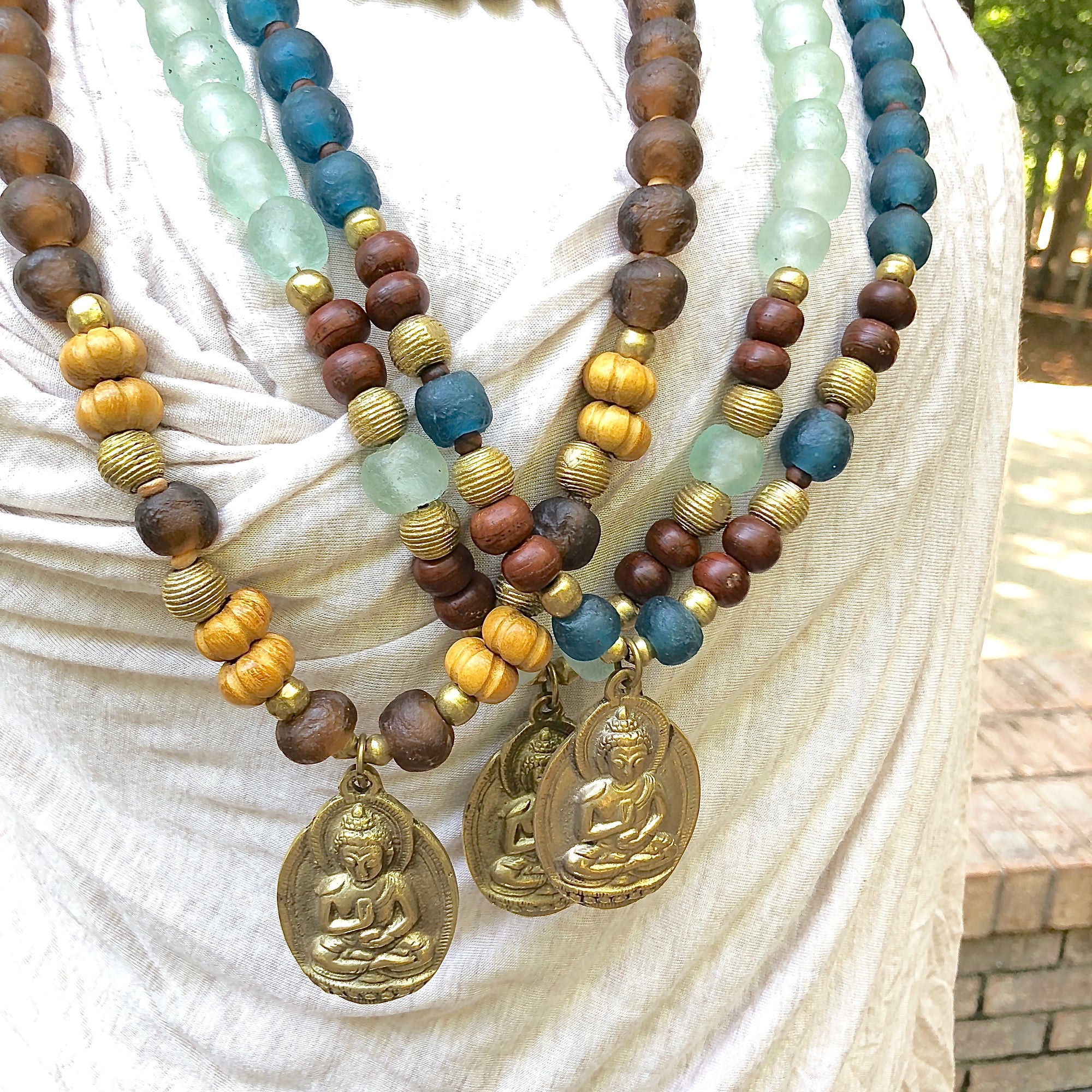 African recycled bottle beads brass Buddha necklace. Cristina Tamames Jewelry Designer